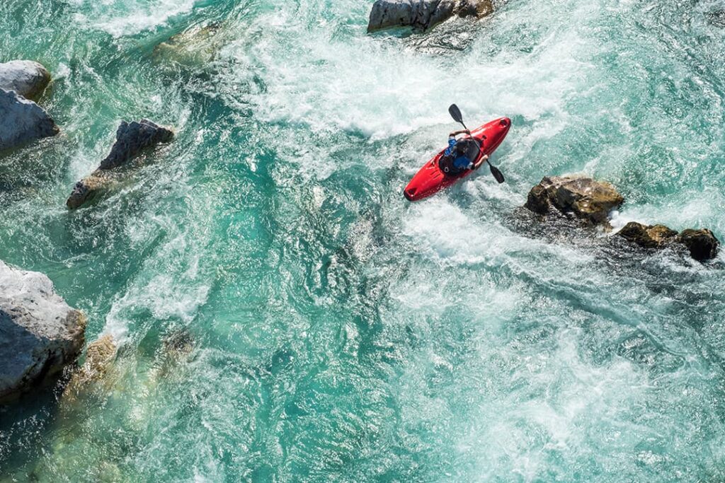 Arial view of kayaker in red kayak on rapids